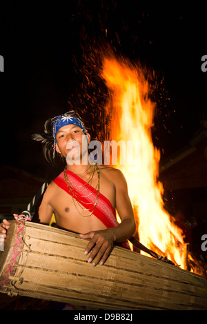 Naga Stammesangehörige spielen Trommel vor Feuer während des jährlichen Hornbill Festival in Kisama, Kohima, Nagaland, Indien Stockfoto