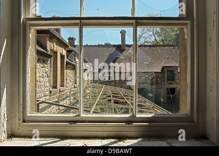 Blick auf ein verlassenes Gebäude durch ein zerbrochenes Fenster Stockfoto