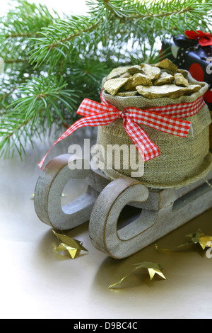 Weihnachten-Zusammensetzung - Filialen ein hölzernen Schlitten mit Geschenken und Tanne Stockfoto