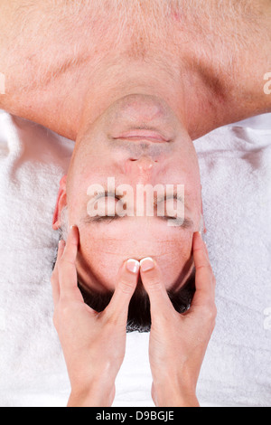 Nahaufnahme von Mann mittleren Alters, Gesichts-Massage von einer Frau empfangen Stockfoto