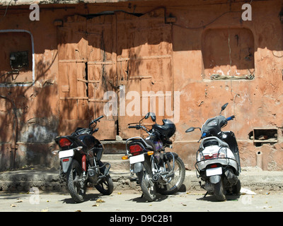 Motorräder geparkt vor alten roten Haus in Jaipur, Indien Stockfoto