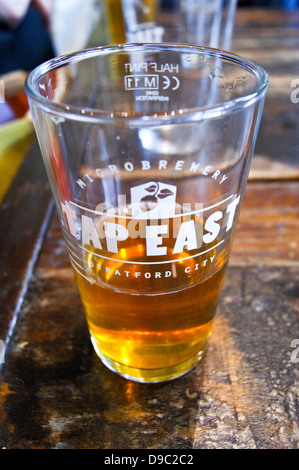 Ein pint Pale Ale in einem gedruckten Glas zu tippen Osten Bar, Westfield, Stratford, London, England. 7/8-Landschaft version RLCG 9 JF pub Tischgetränke glasse Stockfoto