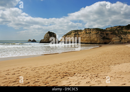 Wellen entlang der goldenen Sandstrand verbauter und ockerfarbenen Klippen von Praia da Rocha an der Algarve, Portugal Stockfoto