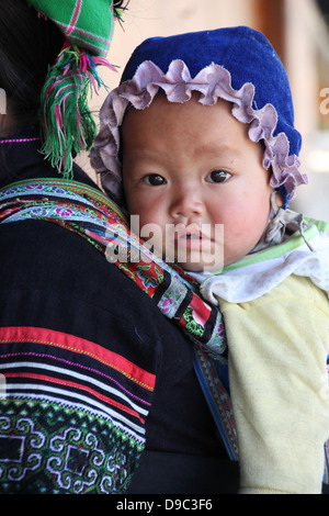 Sapa, Vietnam ca. Feb 2013 baby wenig junge vom indigenen Stamm Black Hmong SaPa, Vietnam auf seiner Mutter zurück Stockfoto