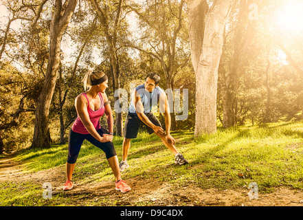 Zwei Menschen, die Bewegung im Wald erstreckt sich aufwärmen zu tun Stockfoto