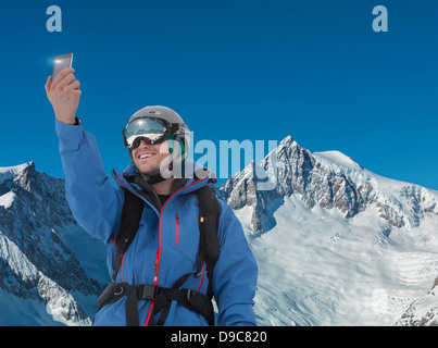 Junger Mann Fotografieren selbst auf Smartphone in Bergen Stockfoto