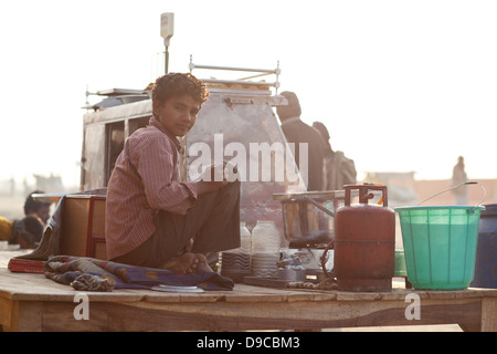 Kleiner Junge bei einem Imbiss-Stand auf der Kumbh Mela in Indien Stockfoto