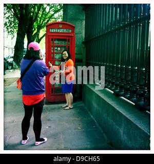 16. Juni 2013 - London, UK - bunte Touristen machen Fotos von sich durch die traditionelle britische rote Telefonzelle befindet sich durch das Tor, das British Museum, London, UK. Mit dem Iphone App Hipstamatic fotografiert (Credit-Bild: © Veronika Lukasova/ZUMAPRESS.com) Stockfoto