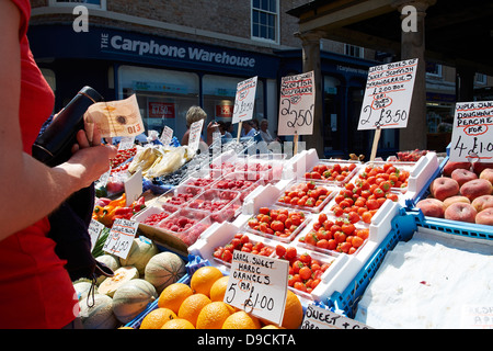 Ein Kunde zahlt für Obst und Gemüse Stand auf Hexham Bauernmarkt. Stockfoto