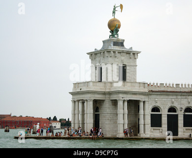 Dreieckigen Punta della Dogana, (das ehemalige Zollhaus der Stadt) trennt den Grand Canal und der Canale della Giudecca in Venedig, Italien. Heute ist es ein Zentrum für zeitgenössische Kunst im 17. Jahrhundert. Der Turm halten sie eine goldene Kugel, das von zwei Atlanten unterstützt wird; diese Statue stellt Vermögen. Es wurde von Bernardo Falconi geformt Stockfoto