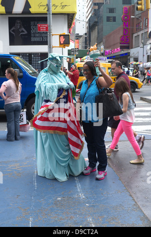 Afroamerikanische Frau mit Fackel Mann verkleidet als Statue of Liberty Times Square, New York City Stockfoto