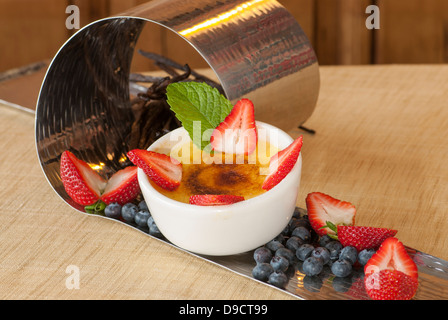 Crème Brûlée mit frischem Obst auf einem Silber Anzeige dienen. Stockfoto