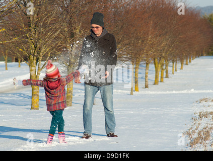 Ein Mann und Kind Spaß im Schnee mit Schneebällen. Stockfoto