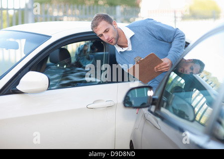 Mann, die Bewertung von Schäden am Auto nach Autounfall Stockfoto