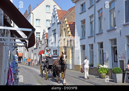 Die vertrauten Anblick von einer Kutsche durch die Straßen von Brügge, Belgien, Europa geritten wird. Stockfoto