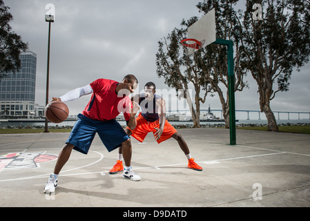 Jungen Basketball-Spieler spielen auf Platz Stockfoto