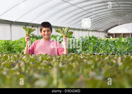 Junge Pflanzen in Kindergarten, hält lächelnd Stockfoto