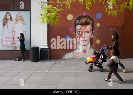 Brixton, London: 18. Juni 2013 - trat ein Wandbild des berühmten Musikers und Sängers David Bowie an der Wand des Morleys Kaufhaus in Brixton, Lambeth, Südlondon. Das Bowie-Gesicht ist (nach Künstler James Cochran, aka Jimmy C) aus der Deckung seines 1973 Album Aladdin Sane auf dem Höhepunkt seines Ruhms der 1970er Jahre stammen. Die pop-Ikone lebte bei 40 Stansfield Road, Brixton, von seiner Geburt im Jahre 1947 bis 1953. Dieses Cover erschien im Rolling Stone Liste der 500 besten Alben aller Zeiten, so dass #277. Bildnachweis: Richard Baker / Alamy Live News Stockfoto