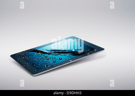 Digital-Tablette mit sanft ansteigenden sprudelnden Wasser auf Bildschirm Stockfoto
