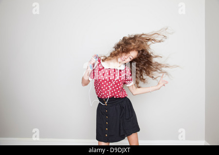 Mädchen mit Kopfhörern, tanzen und halten MP3-player Stockfoto