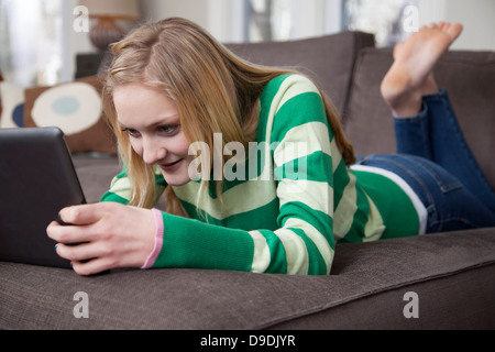 Mädchen liegend auf Vorderseite mit digital-Tablette Stockfoto