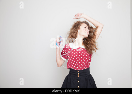 Mädchen mit Kopfhörern, tanzen und halten MP3-player Stockfoto