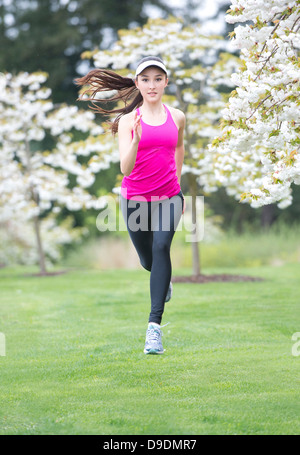 Teenager-Mädchen tragen rosa Sportbekleidung im Park laufen