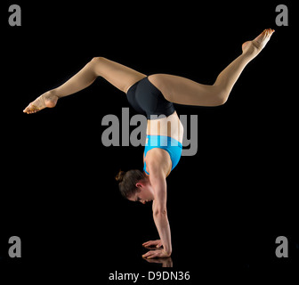 Acrobat durchführen Handstand vor schwarzem Hintergrund Stockfoto