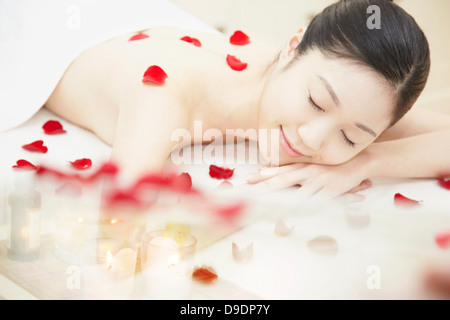 Frau mit Rosenblättern bedeckt Stockfoto