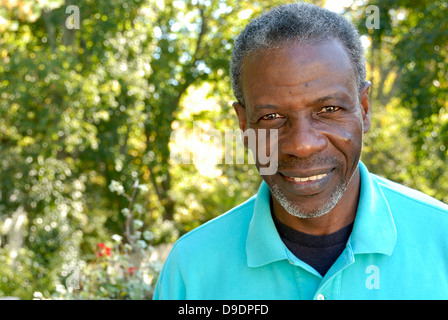 Glücklicher reifer Mann sucht entspannt im Garten Stockfoto
