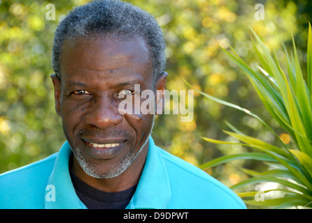 Glücklicher reifer Mann sucht entspannt im Garten Stockfoto
