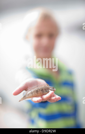 Kleiner Junge mit kleinen Fischen in der hand Stockfoto