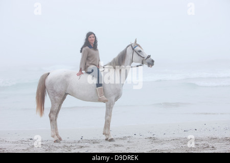 Frau Reitpferd am Strand Stockfoto