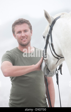 Mann mit Pferd am Strand Stockfoto