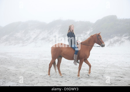 Frau Reitpferd am Strand Stockfoto