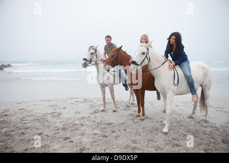 Menschen Reitpferd am Strand Stockfoto