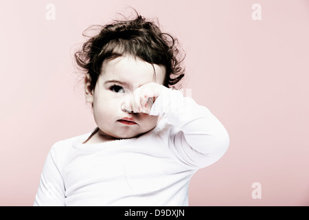 Porträt von Babymädchen Augen reiben Stockfoto