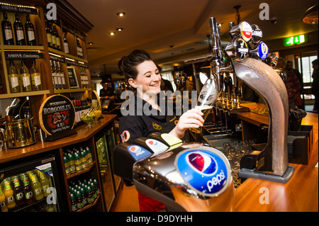 Eine Bardame arbeitet Gießen einen Pint Lager-Bier in einem Pub-Bar-UK Stockfoto