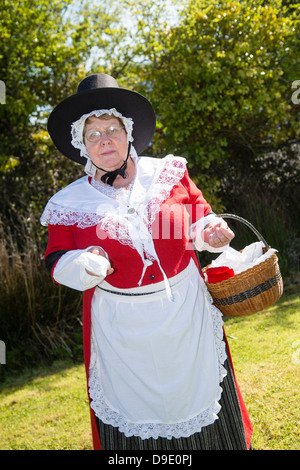 Eine Frau, gekleidet in traditionellen walisischen Kostüm Verkauf von alten altmodischen Süßigkeiten, Kidwelly, Cydweli, Wales UK Stockfoto