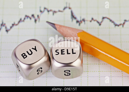 Schnetzelt Würfel mit den Worten verkaufen kaufen, Bleistift und finanzielle Grafik als Hintergrund. Selektiven Fokus. Stockfoto