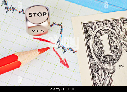 Abwärtstrend finanzielle Diagramm, roten Bleistift, roter Pfeil, Würfel Cube mit dem Wort STOP und ein-Dollar-Banknote. Selektiven Fokus Stockfoto