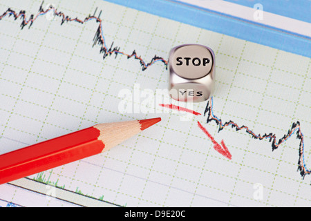 Abwärtstrend Finanzmarkt Diagramm, roten Bleistift, roter Pfeil und Würfel Cube mit dem Wort STOP. Selektiven Fokus Stockfoto