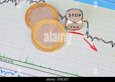 Abwärtstrend Finanzmarkt Diagramm, roter Pfeil, Würfel Cube mit dem Wort STOP und ein-Euro-Münzen. Selektiven Fokus Stockfoto