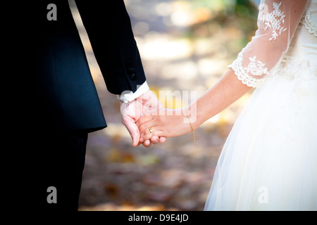 Junge heiratete paar Hand in Hand am Hochzeitstag Stockfoto