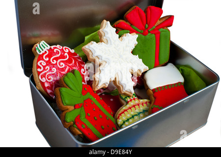 Blechdose gefüllt mit eisgekühlten Weihnachtsplätzchen isoliert auf weiss. Stockfoto