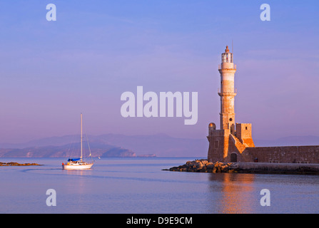 Jahrhundertealter Leuchtturm im malerischen venezianischen Hafen mit Boot in der frühen Morgensonne, Chania, Kreta, griechische Inseln Stockfoto