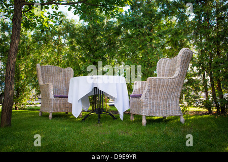 Rattanstühle und einen Tisch im Freien. Stockfoto