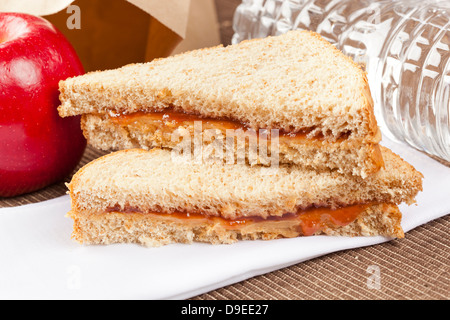 Erdnussbutter und Gelee Lunchpaket mit Wasser und Apfel Stockfoto