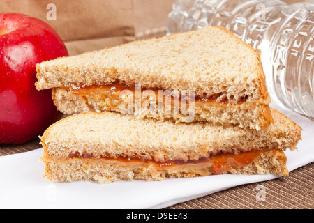 Erdnussbutter und Gelee Lunchpaket mit Wasser und Apfel Stockfoto