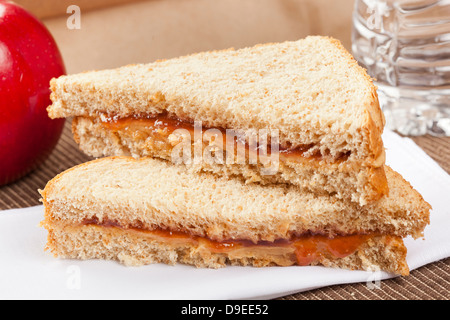 Erdnussbutter und Gelee Lunchpaket mit Wasser und Apfel Stockfoto